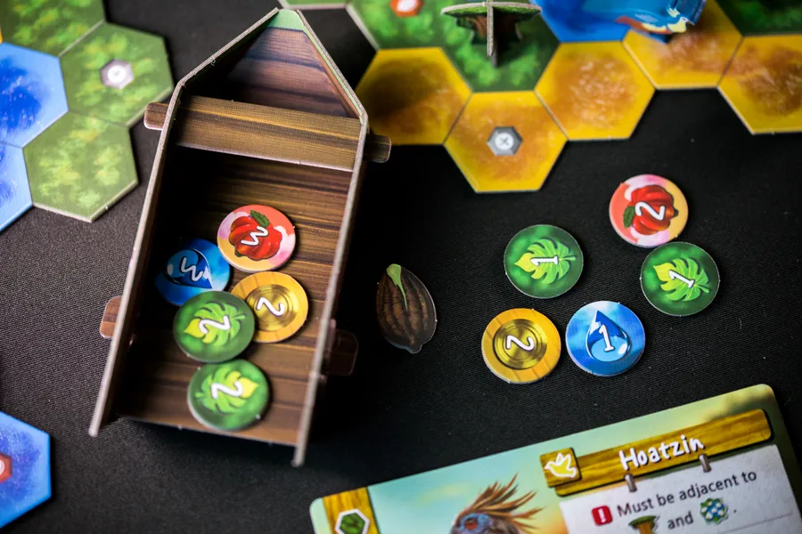 プレイヤーボード上に並んだリソーストークンとボートに捨て札されたトークン