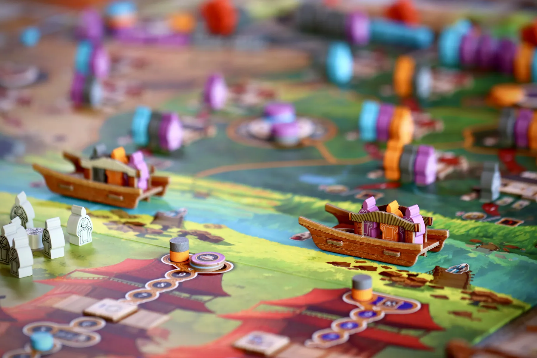 ボードゲーム「天下」の収入フェイズで、バージ上の労働者から資源を獲得している盤面